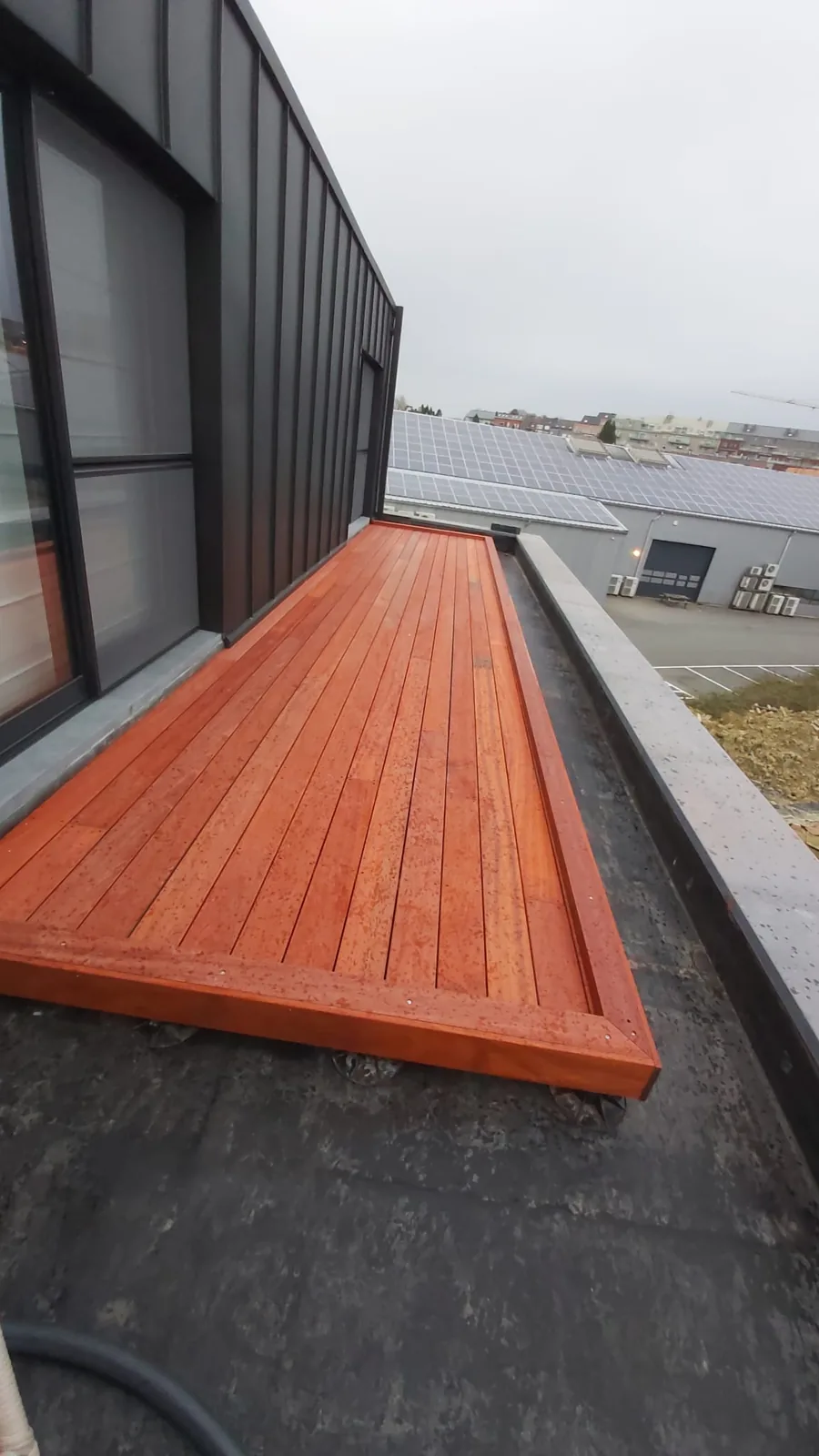 Terrasse bois sur toiture avec bardage sombre