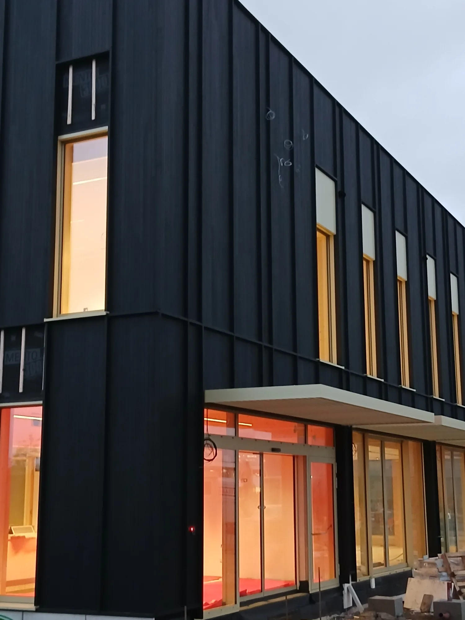 Angle de façade bois sombre avec ouvertures lumineuses